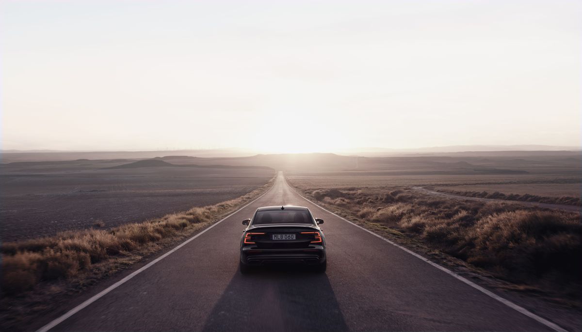 rear shot of 2022 volvo s60 black edition for the us market on open desert road