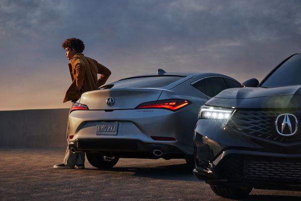 model with 2023 acura integra sports sedan in silver; another acura is in foreground